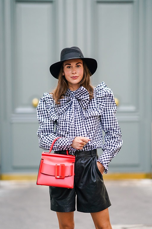 PARIS, FRANCE - SEPTEMBER 03: Therese Hellström wears a black hat from Maison Michel, a red leather bag from BOYY, black leather shorts from Custommade, a ruffled blue and white checkered blouse / shirt with bow tie from Custommade, on September 03, 2020 in Paris, France. (Photo by Edward Berthelot/Getty Images)