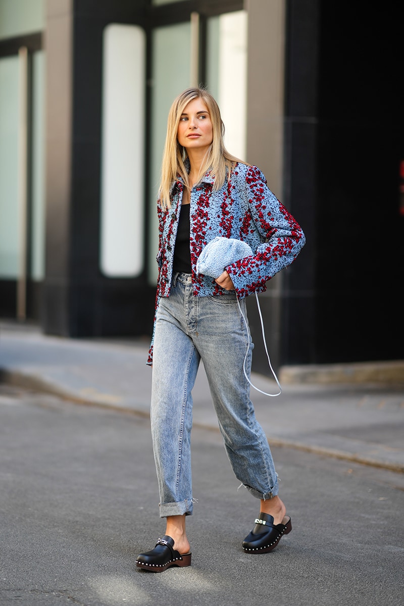 PARIS, FRANCE - APRIL 27: Xenia Adonts wears a black ribs t-shirt, a pale blue and red embroidery Bottega Veneta tweed jacket, blue faded denim ripped rolled-up boyfriend jeans Ksubi pants, pale blue and white braided Bottega Veneta handbag, black shiny leather nailed Hermes mules block heels shoes, on April 27, 2021 in Paris, France. (Photo by Edward Berthelot/Getty Images)