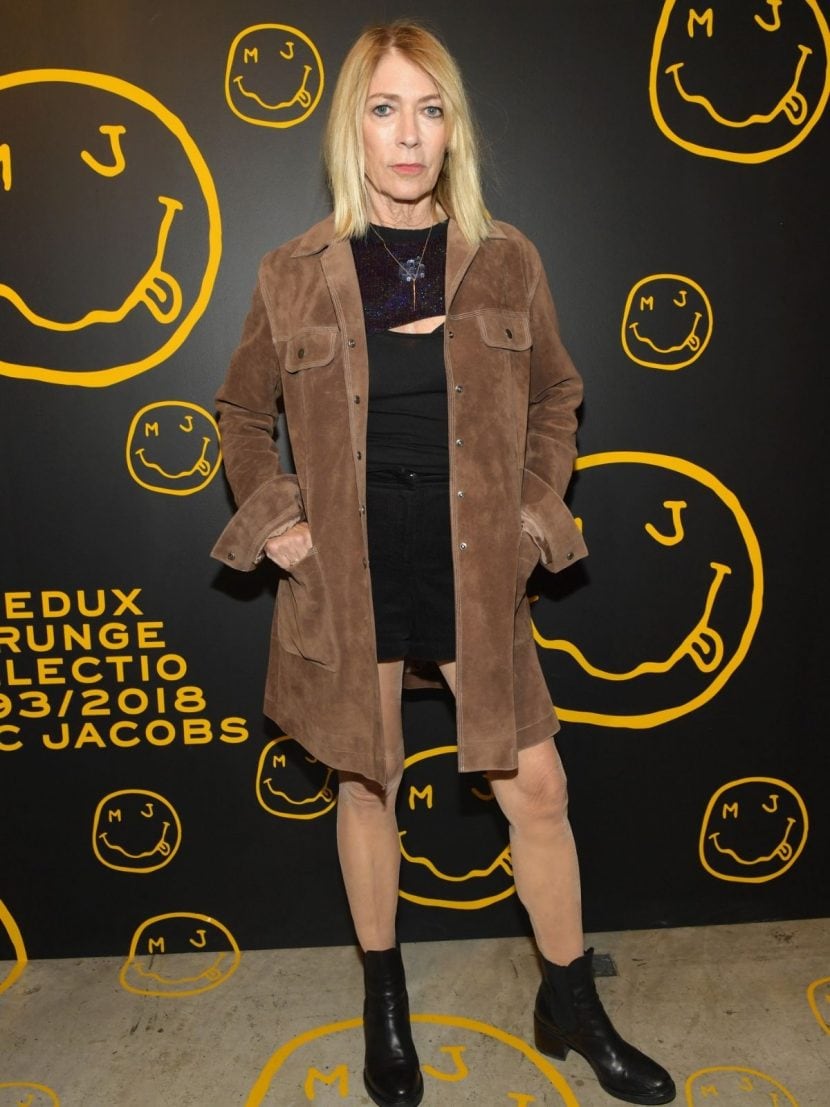 Kim Gordon presenzia ad un evento grunge vestita di nero con giacca color cammello